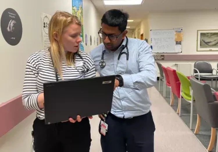 Two Radiation Oncologists in discussion over a result in a laptop