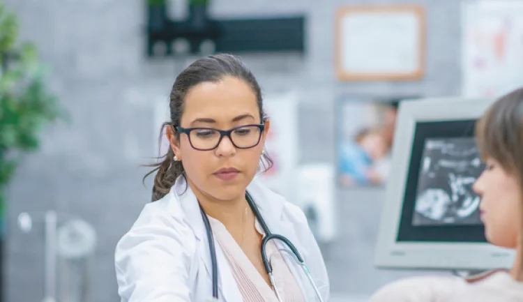 Sonographer looking down with a stethoscope (stock image)