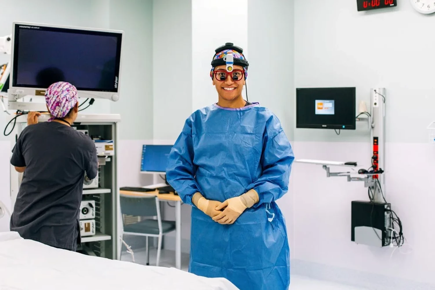 A surgeon standing next to a busy operating theatre nurse on her left