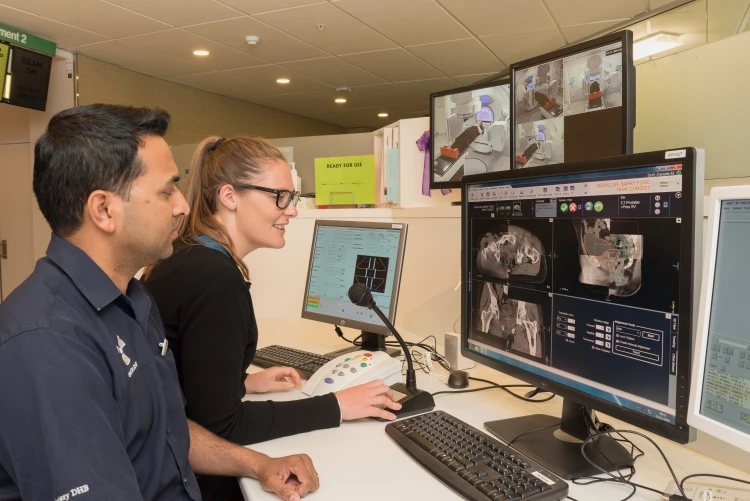 Two Radiation Therapists checking some scans together on the display monitor in the oncology department.