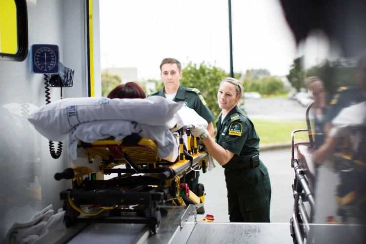 A couple of St. John paramedics carefully loading a patient into the ambulance